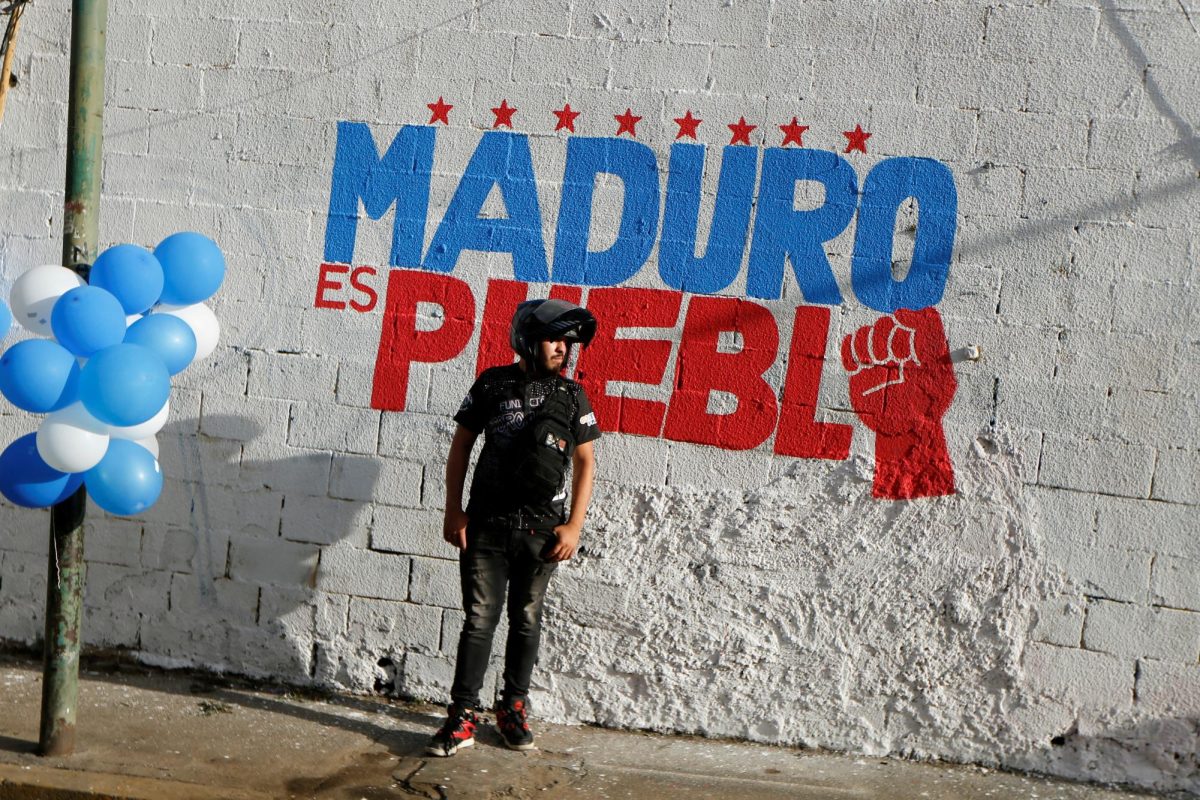 A man stands in front of a mural for the reelection campaign of President Nicolas Maduro during a rally of the United Socialist Party of Venezuela (PSUV) in support of Maduro, in Caracas, Venezuela June 20, 2024. REUTERS/Leonardo Fernandez Viloria