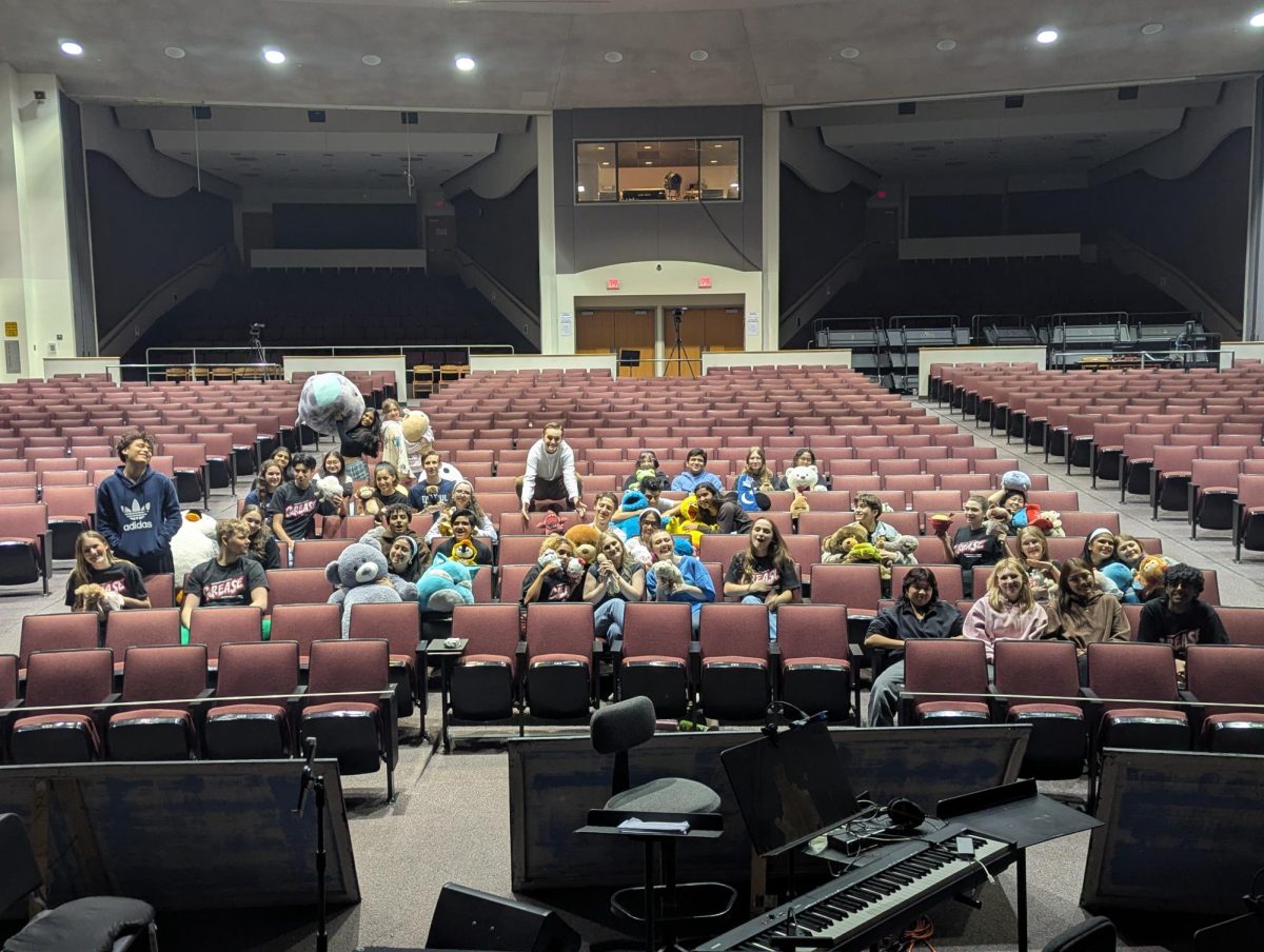 Cast and crew posed in the auditorium on their “soft” opening on 4/29, holding up stuffed animals they brought in to act as their first audience before opening night